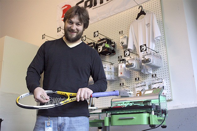 Stephen Stchur takes the old strings out of a tennis racquet near his Prince 6000 stringing machine in his garage workshop in Carnation. He recently moved to the city from Sammamish.