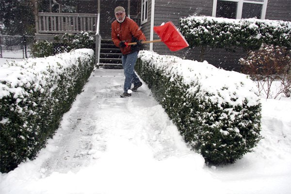 Terry O’Brien of Snoqualmie scoops out his sidewalk after a snowy night. Valley residents should prepare for winter conditions by stocking up on supplies for the car and home.