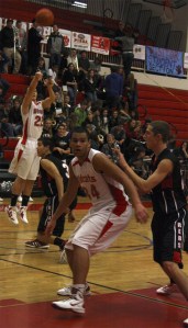 Mount Si's Jason Smith fires a three as Anthony McLaughlin gets into position by the basket