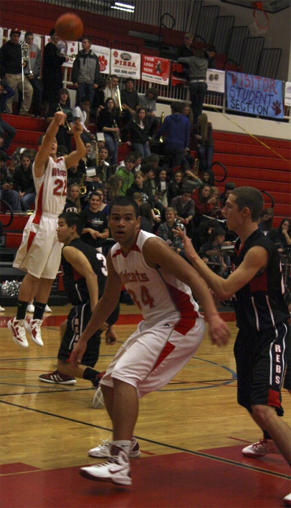 Mount Si's Jason Smith fires a three as Anthony McLaughlin gets into position by the basket