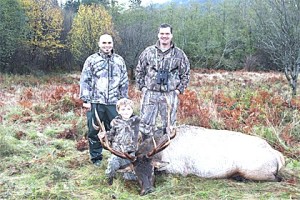 Snoqualmie Elementary second grader George Vincent with Mark Torres (left) and his dad Mike Vincent (right) shot down a 750-pound elk in the first five minutes of the elk season.