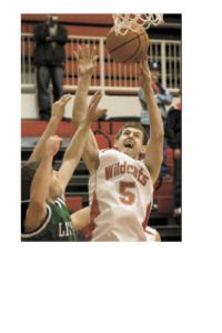 Wildcat Spencer MacEwan rips a rebound down over Liberty defenders in the Dec. 9 home win.