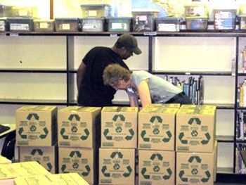 Rotarians Jeetendra Fallodia and Mary Lou Dreher pack books at the Carnation Elementary Library. The school library is slated for renovations this summer.