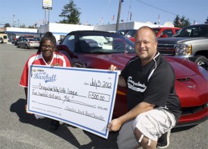 Leesa McKay of Chaplins North Bend Chevrolet hands a big donation to Roy Baunsgard