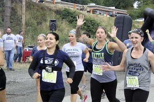 Participants run out of the gate during the 10 a.m. wave excited for the 3.5 mile obstacle course.