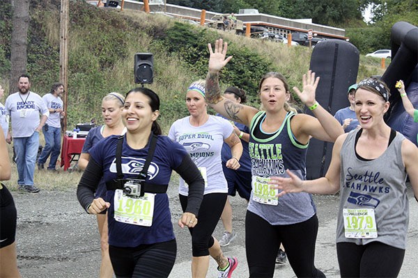 Participants run out of the gate during the 10 a.m. wave excited for the 3.5 mile obstacle course.