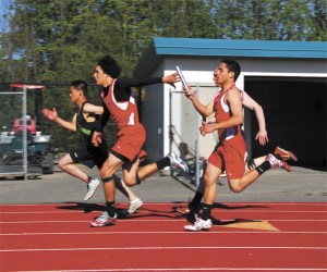 Kaleb Huerta hands off to Mason Bragg in the boys’ 4x100 relay Wednesday at Sea-King districts. The relay team of Huerta