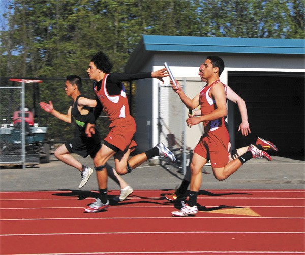 Kaleb Huerta hands off to Mason Bragg in the boys’ 4x100 relay Wednesday at Sea-King districts. The relay team of Huerta