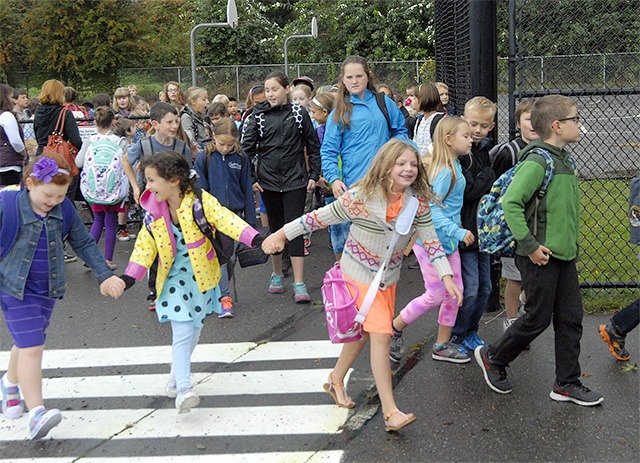 Friend link hands as they head to the first day of class on Wednesday