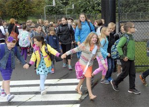 Friend link hands as they head to the first day of class on Wednesday
