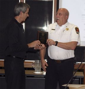 Snoqualmie Fire Chief Bob Rowe accepts a plaque honoring his 15 years with the city.