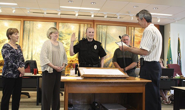 Family members surround newest Snoqualmie officer Justin LeRoux as Mayor Matt Larson swears him in.