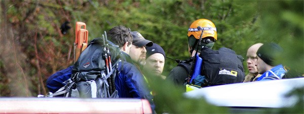 King County search teams and firefighters assemble in a parking area near the Middle Fork of the Snoqualmie River before hiking to the site of a plane crash Wednesday on Mount Si.
