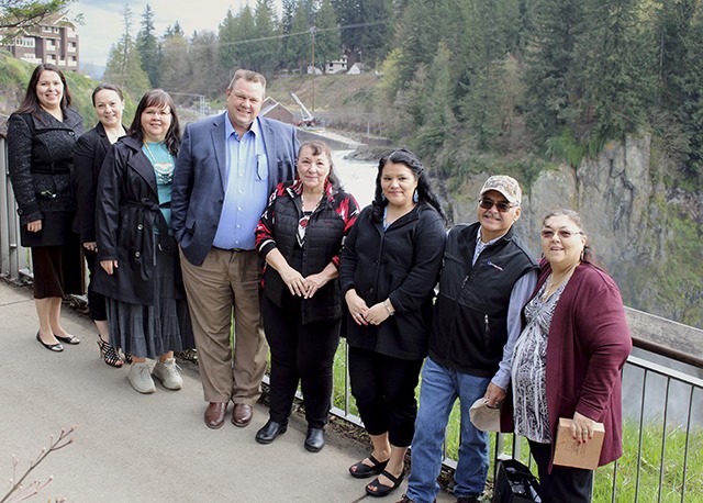 Sen. Jon Tester poses near Snoqualmie Falls with Snoqualmie tribal council members.