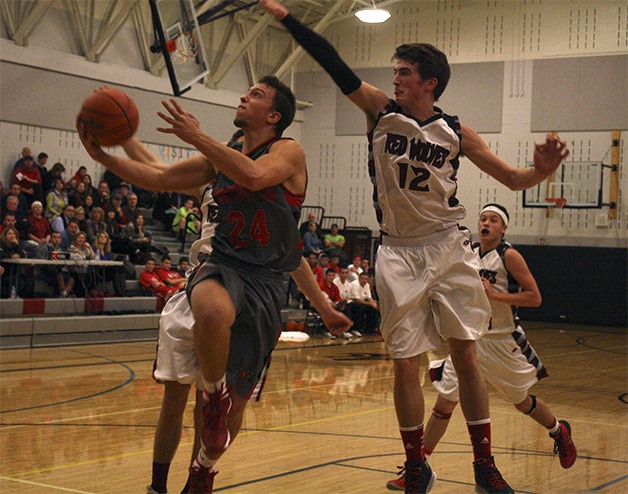 Wildcat Beau Shain pushes for a bucket as Cedarcrest’s Nick Peden defends last Saturday