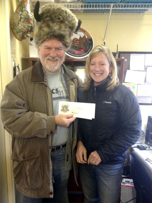 Sallal Grange Master Larry Houch presents a check for turkeys to Food Bank Director Heidi Dukich.