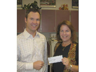 Fall City Days committee President Judy Dix presents Fall City Elementary School Principal Dan Schlotfeldt a check for $1