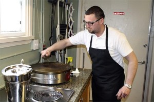 Sinacia Yovanovich readies the crepe griddle for the day with a few scrapes of the spatula in his immaculate kitchen at the Eurolounge Cafe