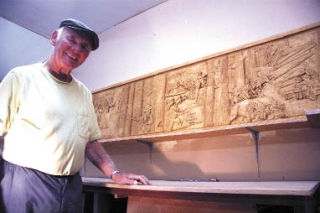 Adi Hienzsch stands in front of his carving of Snoqualmie Valley’s history for North Bend’s Centennial block party. The carving