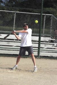Dr. Kirby Nelson connects with a pitch during a softball match between his othodontic office team