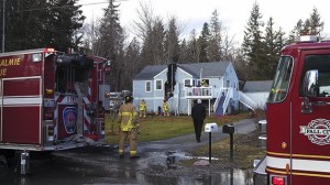 Snoqualmie firefighters examine the scene of a structure fire that broke out midday Monday