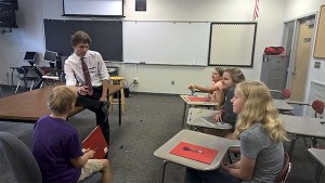 Ruary Thompson explains debate to interested students during a speech and debate camp held this summer.