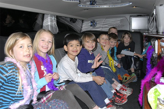 First graders from North Bend Elementary School get buckled in and swathed with feather boas for their celebrity trip through North Bend in a stretch Hummer limousine. The students earned the experience by making the most sales in a North Bend PTA fundraiser. Pictured from left are Marissa Bergh