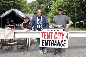 Camp advisors Sam Roberson and Perry Debell pose outside of the entrance to the Puget Sound area’s newest homeless encampment