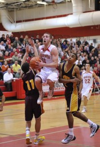 Wildcat senior Zander Nelson leaps into midair between two O’Dea defenders to attempt a lay-up basket. He sunk 21 on the night last Tuesday in the ‘Cats’ final game.