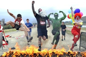 Costumed teams navigate obstacle courses of mud and fire in the Warrior Dash