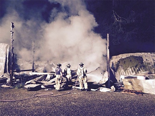 Firefighters extinguish remnants  of the April 13 barn fire.