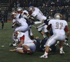 Mount Si senior Keenan McVein pushes through the Glacier Peak line during a carry in the first quarter of Friday’s game. Also pictured are Bradly Christensen