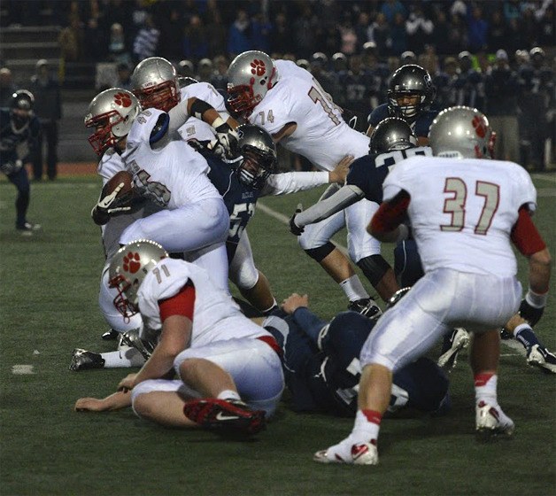 Mount Si senior Keenan McVein pushes through the Glacier Peak line during a carry in the first quarter of Friday’s game. Also pictured are Bradly Christensen