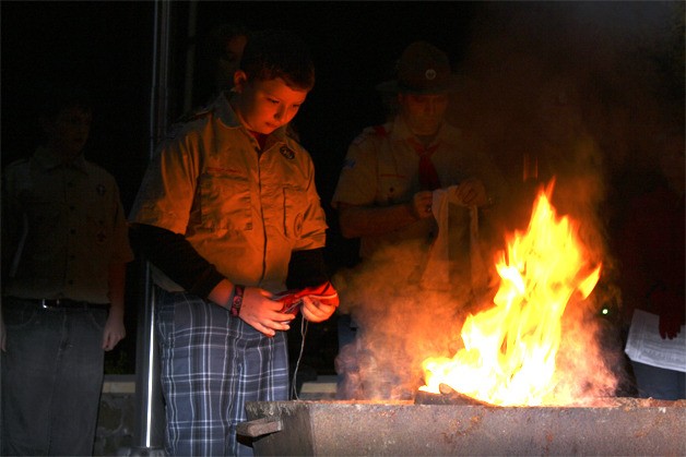 Boy Scouts and leaders with Fall City's Troop 425 humbly retire worn and faded American flags on an alder fire on November 8. Scouts follow the code of the flag