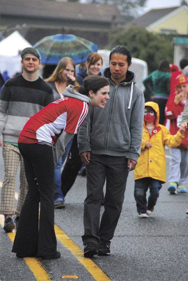 Visitors react to ‘Slow Walkers’ at the 2011 Fall City Days. The slow-motion performance art returns to perplex and involve this June.