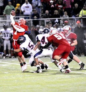 Mount Si quarterback Ian Ilgenfritz looks for a handoff as Juanita’s Dom Chadwick closes in during the final offensive drive of the night on Oct. 15. Wildcat Jimmy Owen