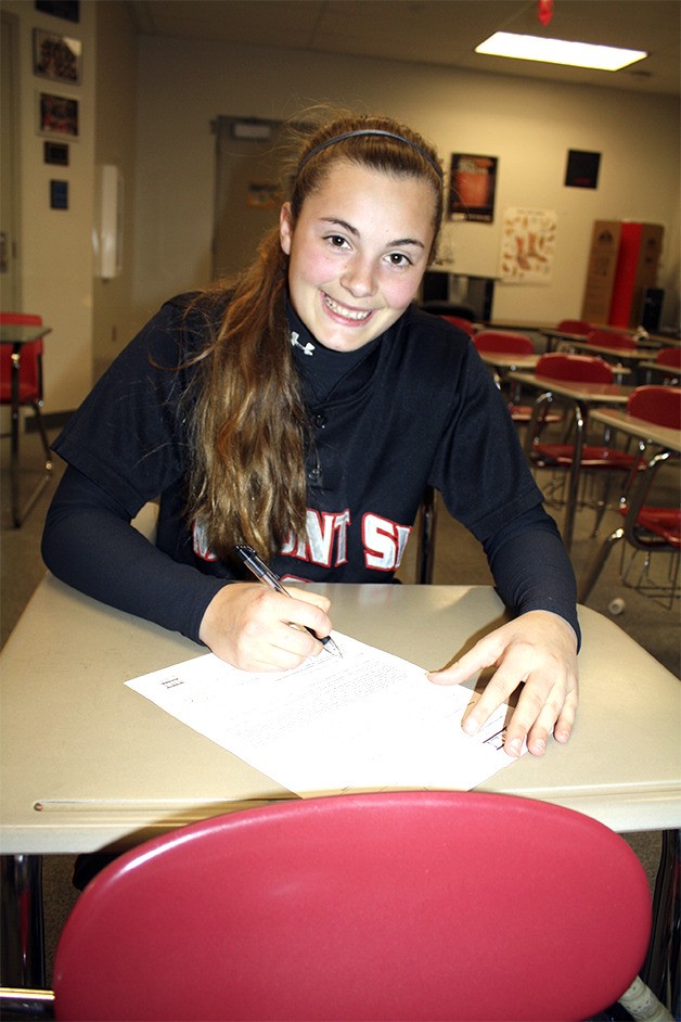 Tamarra Crowe signs her college papers for play next fall at Merrimack.