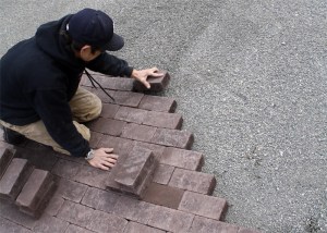 Brian Gray of Mr. K’s Construction lays a row of brick pavers at the new Snoqualmie Valley Veteran’s Memorial. A plaza at the site includes personalized bricks with messages of remembrance and patriotism. The $40