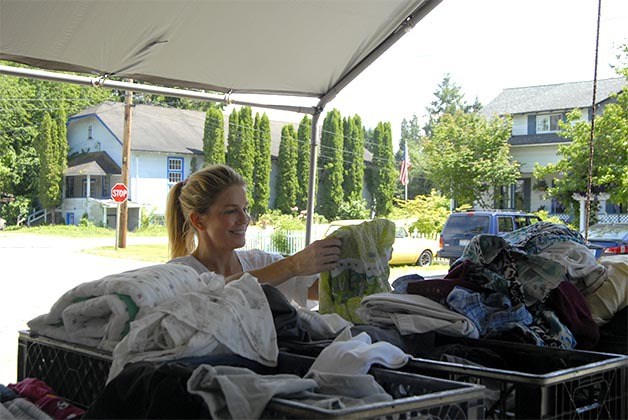 Elizabeth Wing folds some clothes she is donating to the new Carnation Public Food Bank on Myrtle Street.