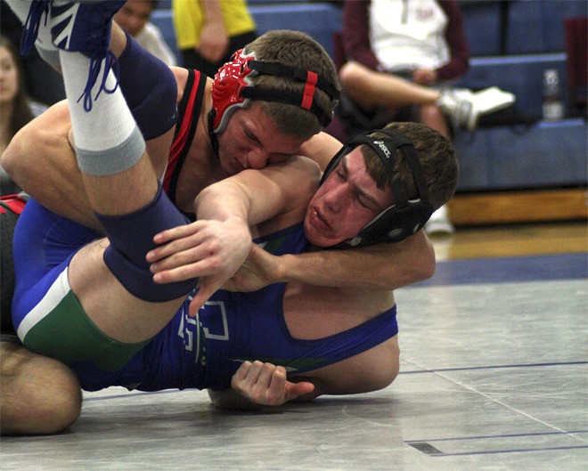 Mount Si senior AJ Brevick handles Quinn Magendanz of Liberty to claim third at 160 pounds during league tournament mat action Saturday
