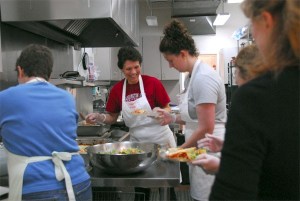 Kitchen staff gather around cook and nutritionist Jennifer Berg to begin serving lunch in their first week back at Sno-Valley Senior Center in Carnation. One of the upgrades completed in the remodel was a new stove for the kitchen