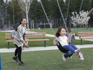 Katie Monica pushes her daughter