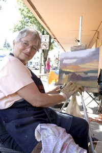 Sandy Robinson paints out of doors in the 2011 North Bend Block Party. She returns this weekend with other Valley creators to the Artists' Alley.