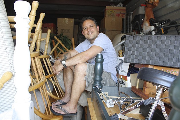 Don Baunsgard squeezes into a filled Eastside Self Storage locker overflowing with furniture