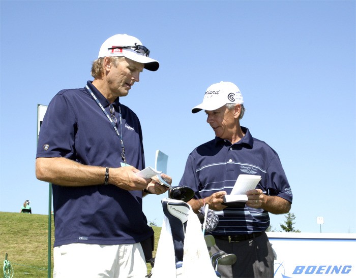 confers with caddy Tim Mork on the best approach to hole 14 on the Snoqualmie Ridge TPC. Mize tied for 23rd in the Classic.