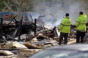 King County Sheriff's officers inspect the rubble of the former Pizza Place on East North Bend Way Friday morning