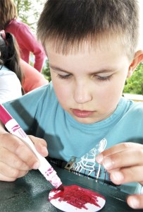 Preschooler Grayson Young of Snoqualmie colors an Encompass logo button during the organization’s last-day-of-school picnic on June 16. Last month