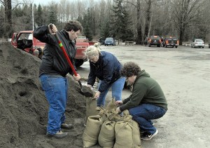 Skyler Possert shovels sand while his mom