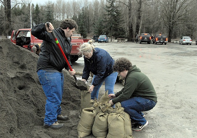 Skyler Possert shovels sand while his mom