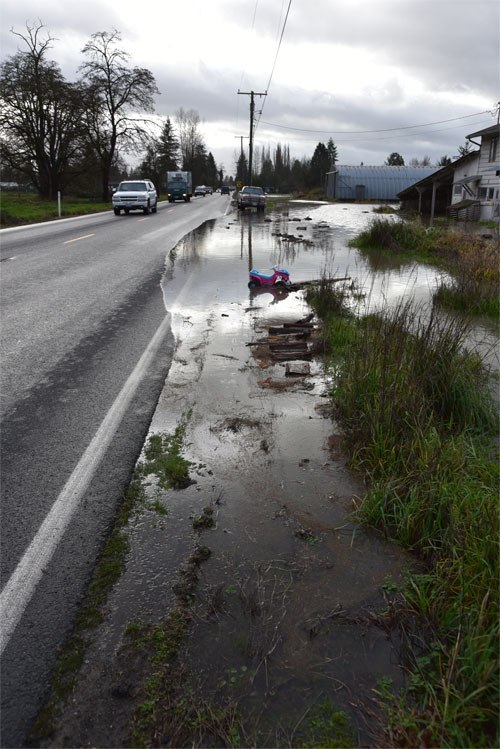 Water creeps over the edge of State Route 203 just north of Carnation around 11 a.m. Wednesday.